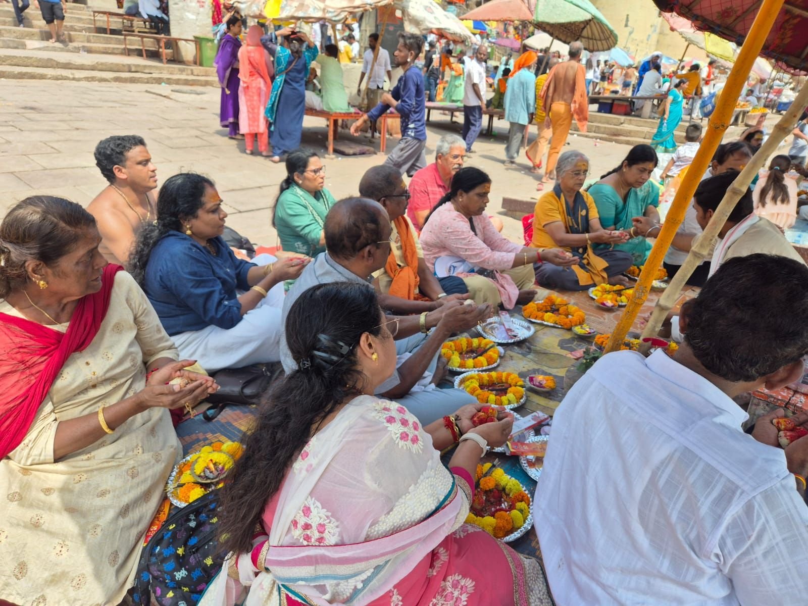 Tour group participating in evening pooja ceremony at Dashashwamedh Ghat on the banks of the Ganga River in Varanasi