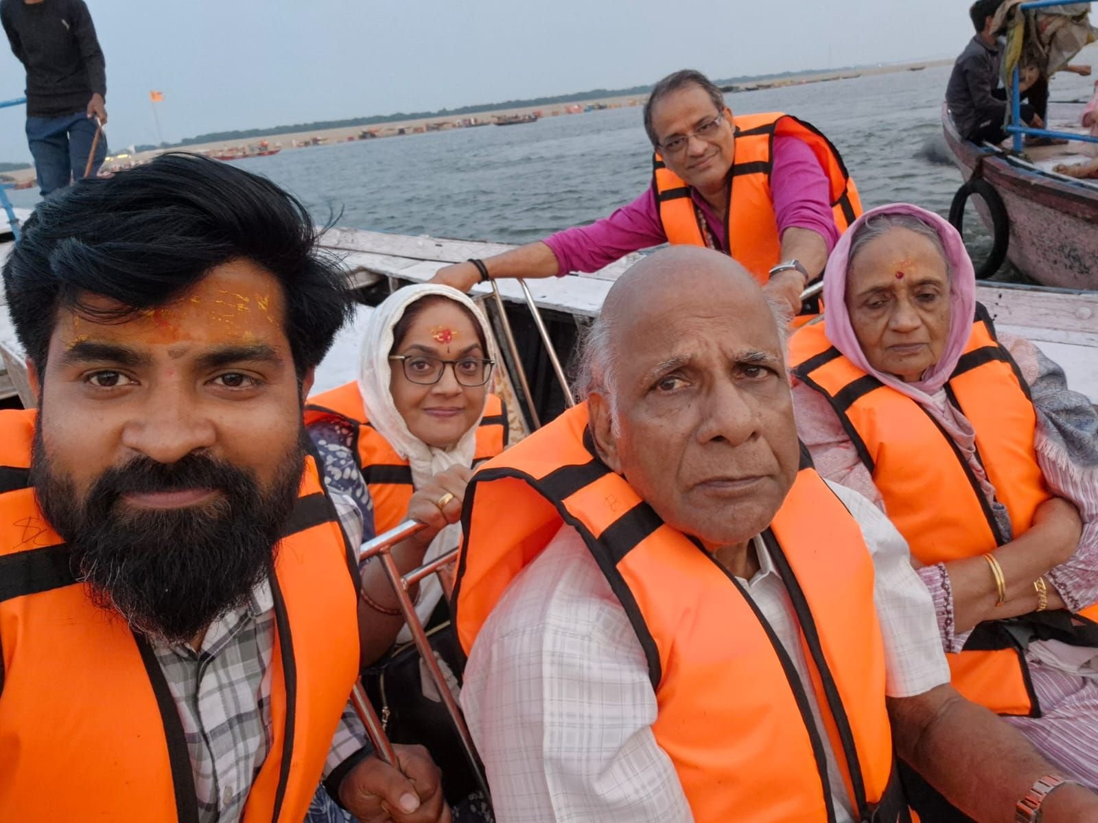 Tour group enjoying a scenic boat ride along the Varanasi Ghats on the Ganges River during sunrise